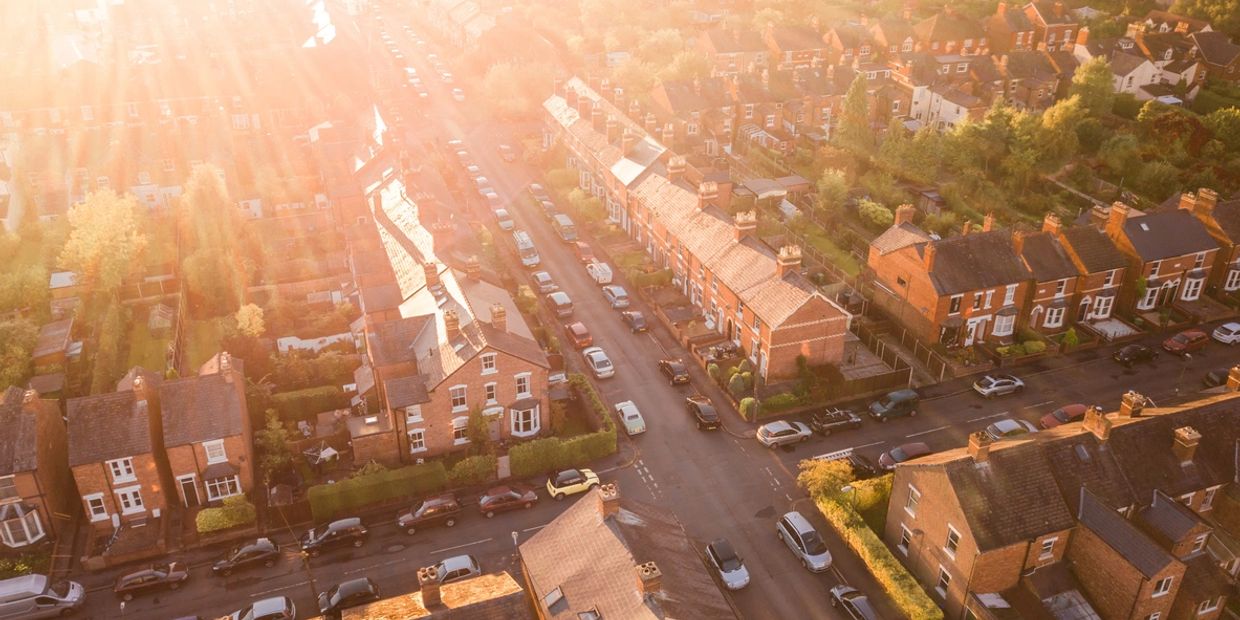Aerial view of a residential neighborhood bathed in warm sunlight.