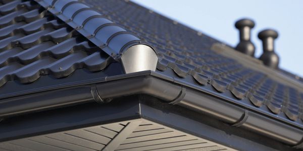 Black gutters around a black spanish tile roof