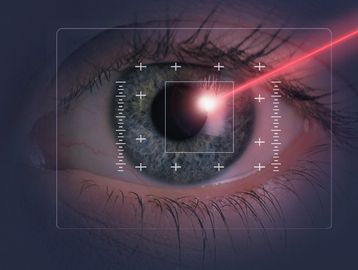 Close-up of an eye with a red laser and digital targeting overlay.