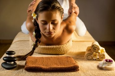 Woman receiving a relaxing massage in a serene spa setting.