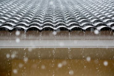 Stormwater design, rain falling onto house roof tiles