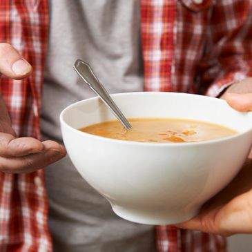 Someone handing a person a bowl of warm soup for Givelist project to assist homeless friends.