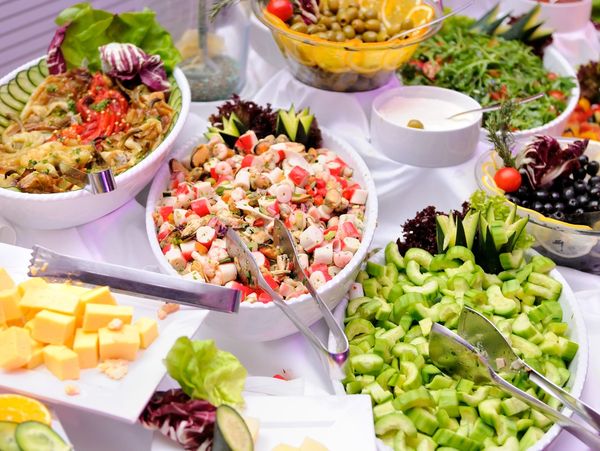 A colorful buffet spread with fresh salads, fruits, and cheeses.