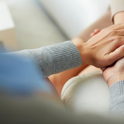 A close up image of a person holding their own hand