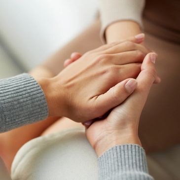 one person holding another person's hand in both hands