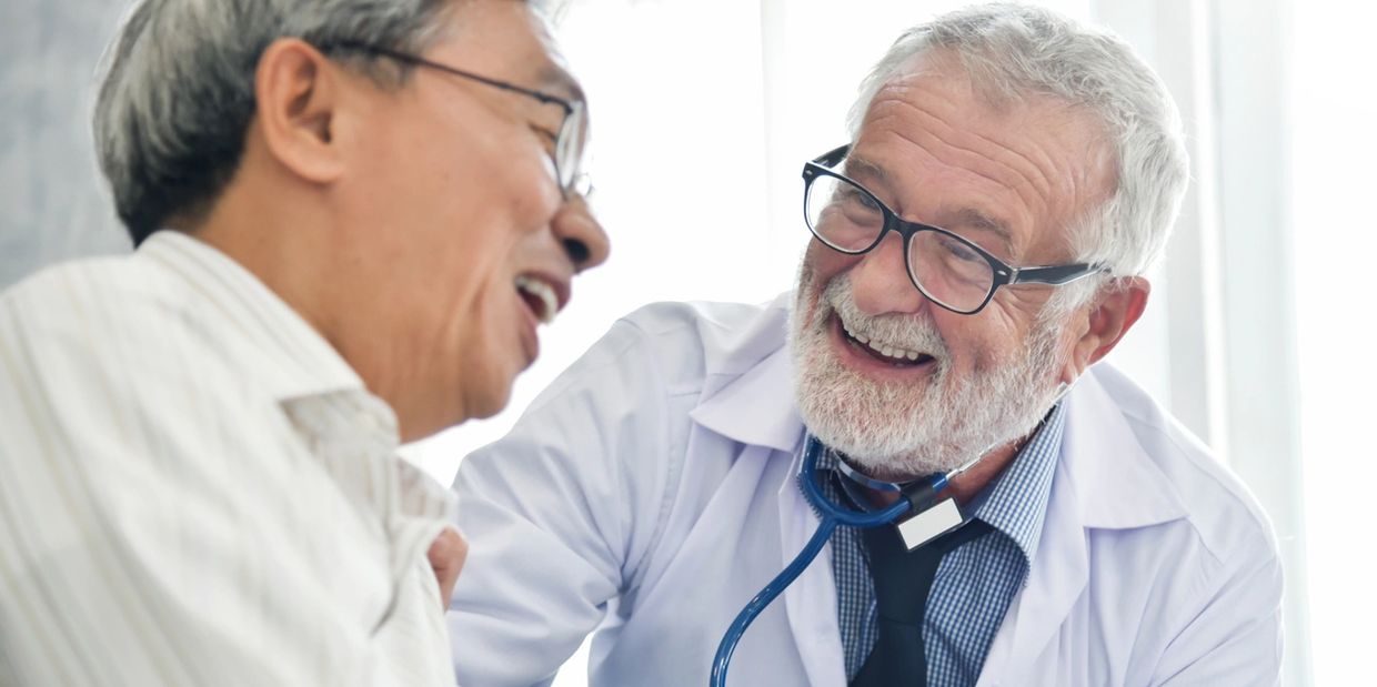 An amazing doctor laughing with his patient. 