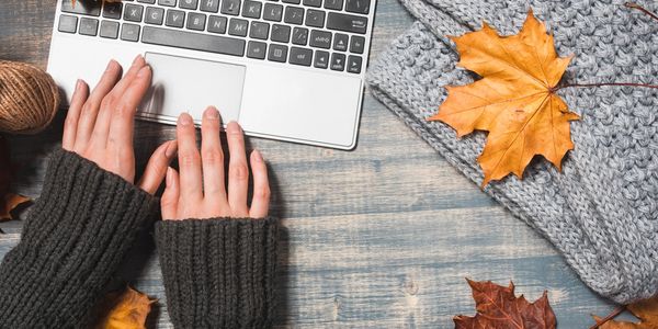 Woman on her laptop with leaves all around 