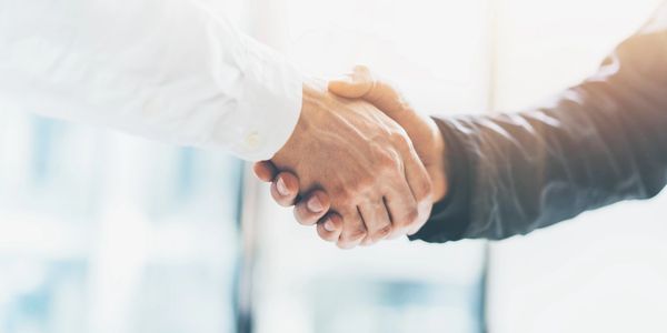 Interagency and Intergovernmental Coordination handshake amongst 2 people