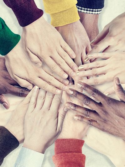 Diverse hands joined together in unity.