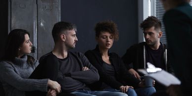 Four people sitting in chairs facing away from a locker