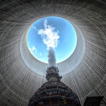 A scenic landscape featuring mountains, a river, and lush greenery under a clear blue sky.