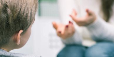 Child and therapist talking in kids counseling session. 