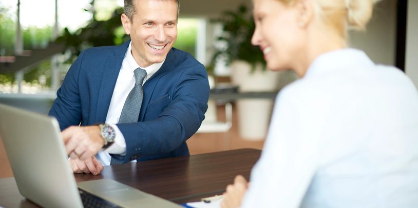 Two professionals smiling during a meeting.