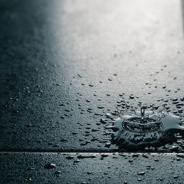 Water drops from a leak on a tile floor