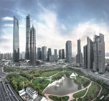 City skyline with modern skyscrapers and park lake.