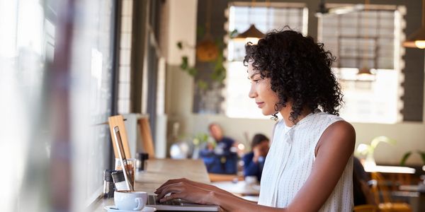 Woman working on laptop in a cozy cafe.
