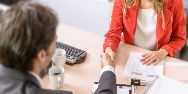 a male and female shaking hands in a work environment