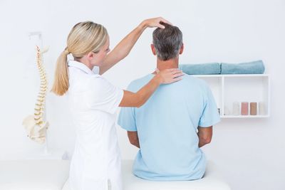 Chiropractor giving a male patience an exam.