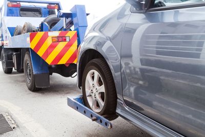Car being towed by a tow truck.