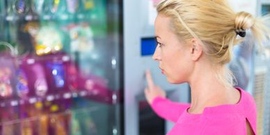 women selecting items out of a vending machine 