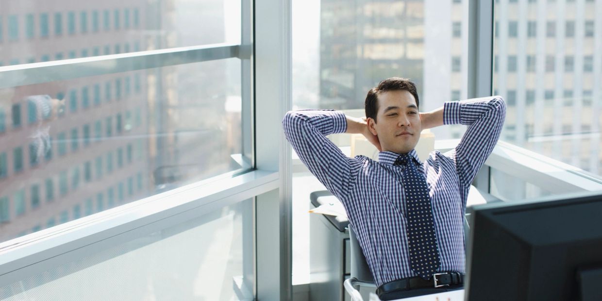 Man relaxing at office desk.