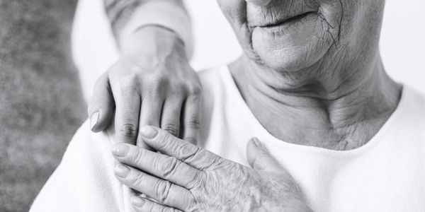 Elderly lady touching hand with another lady