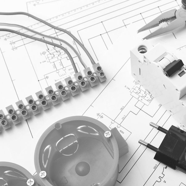 Electrical components arranged on technical circuit diagrams with tools.