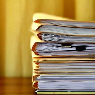 A pile of accounting papers on a table, symbolizing financial record-keeping.