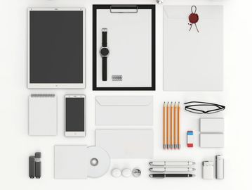 A flat lay of various blank white and black branding and office supplies