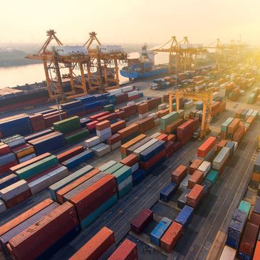 A busy shipping port with many colorful containers at sunset.