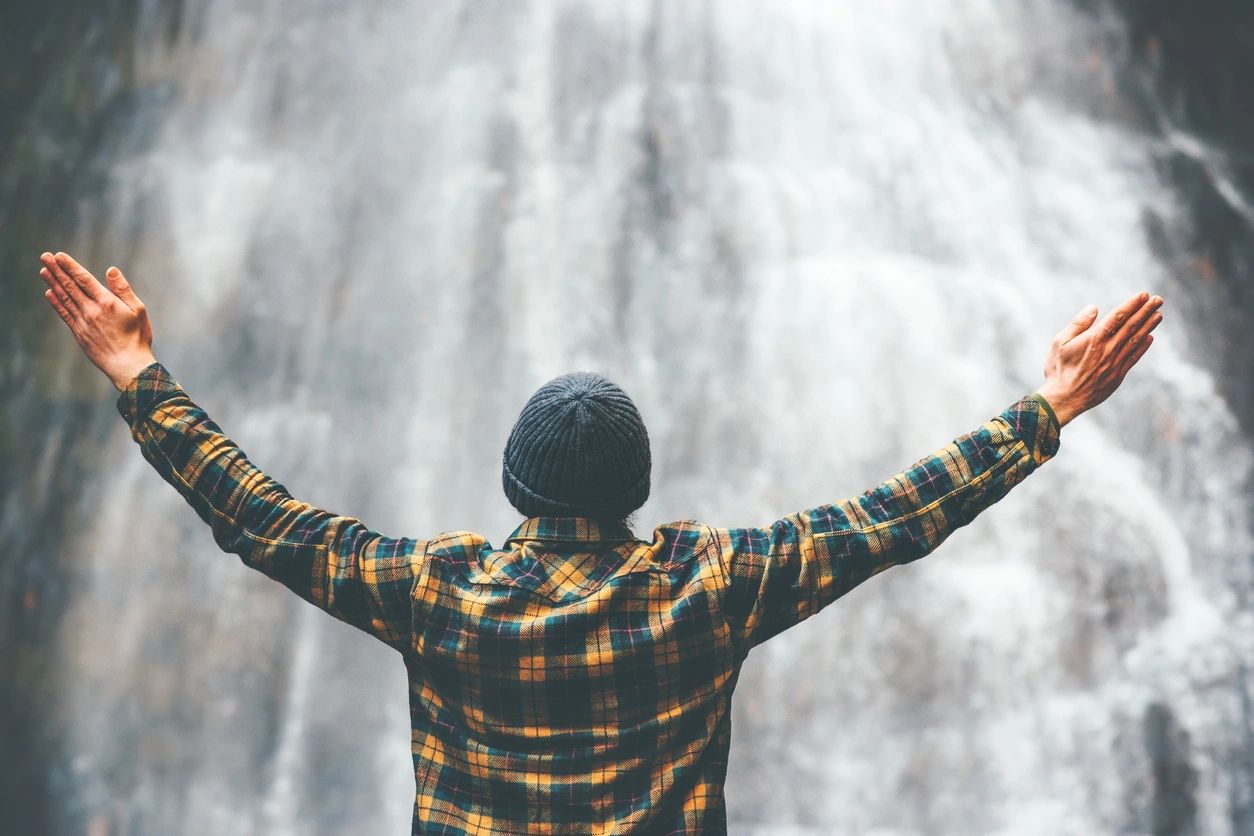 picture of a man in front of a waterfall.