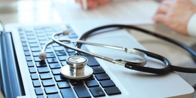 Stethoscope resting on a laptop keyboard symbolizing digital healthcare.