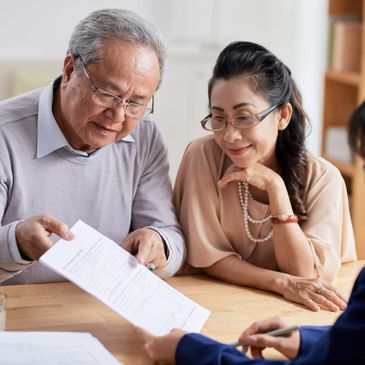 Elderly couple reviewing documents with a professional.