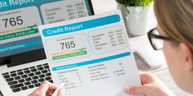 A woman overlooking a credit report with a 765 score.