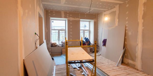 newly plaster boarded room with old wood floor with a yellow platform in the center