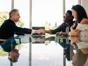 Business professional shaking clients' hands.