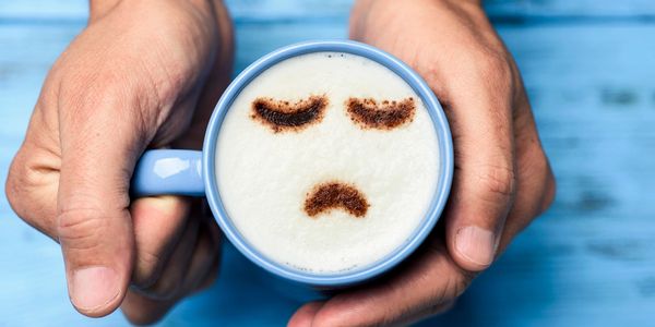 Sad face in coffee cup