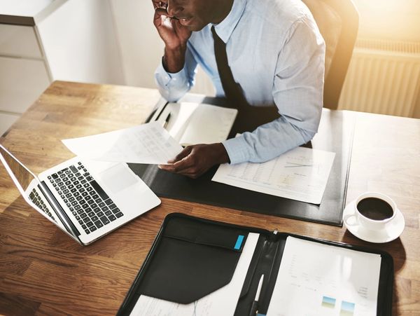 A business man talking on the phone and looking on documents