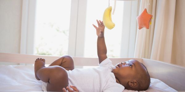 Toddler trying to hold the toy banana