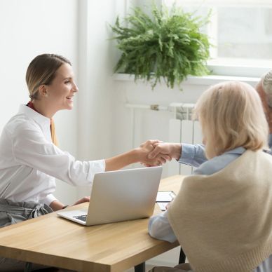 Notaire accueillant un couple âgé pour une consultation notariale.