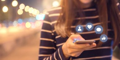 Woman holding a cellphone with social media icons displayed