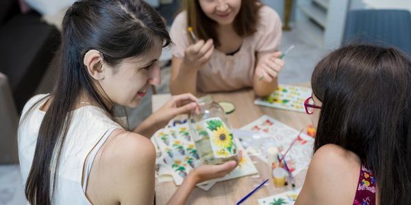 Three women enjoying a creative painting session together.