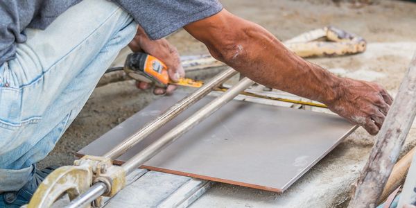 Tile contractor measuring tile for installation
