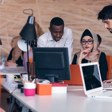 Team collaborating around a computer in an office.