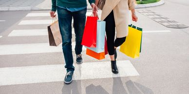 A man and woman carrying several shopping bags.