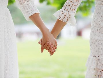 Two brides holding hands. Lesbian couple. 