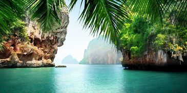 Scenic tropical bay with turquoise water and lush cliffs.