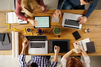 A group of men and women sitting around a table for a marketing strategy and brainstorming meeting.