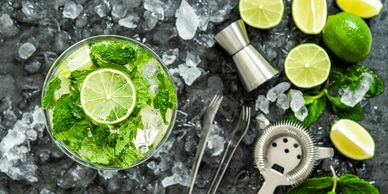 Top view of a mojito cocktail with lime and mint on ice.