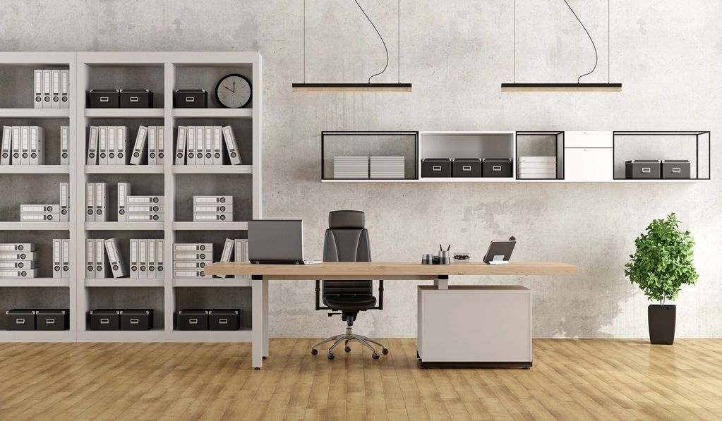 Minimalist office with organized shelves, a wooden desk, and a black swivel chair.